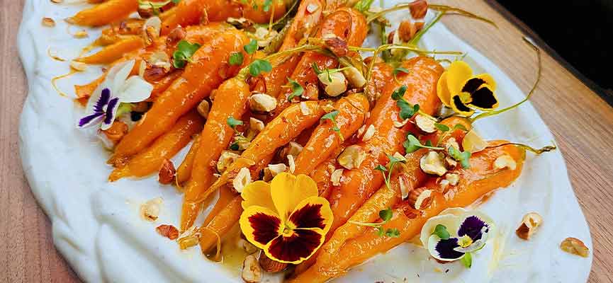 Carottes glacées au miel, sauce au yogourt et noisettes torréfiées